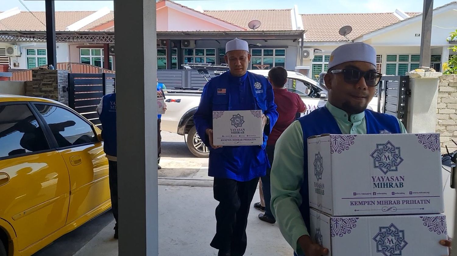 Sukarelawan membawa kotak bantuan ke rumah penerima