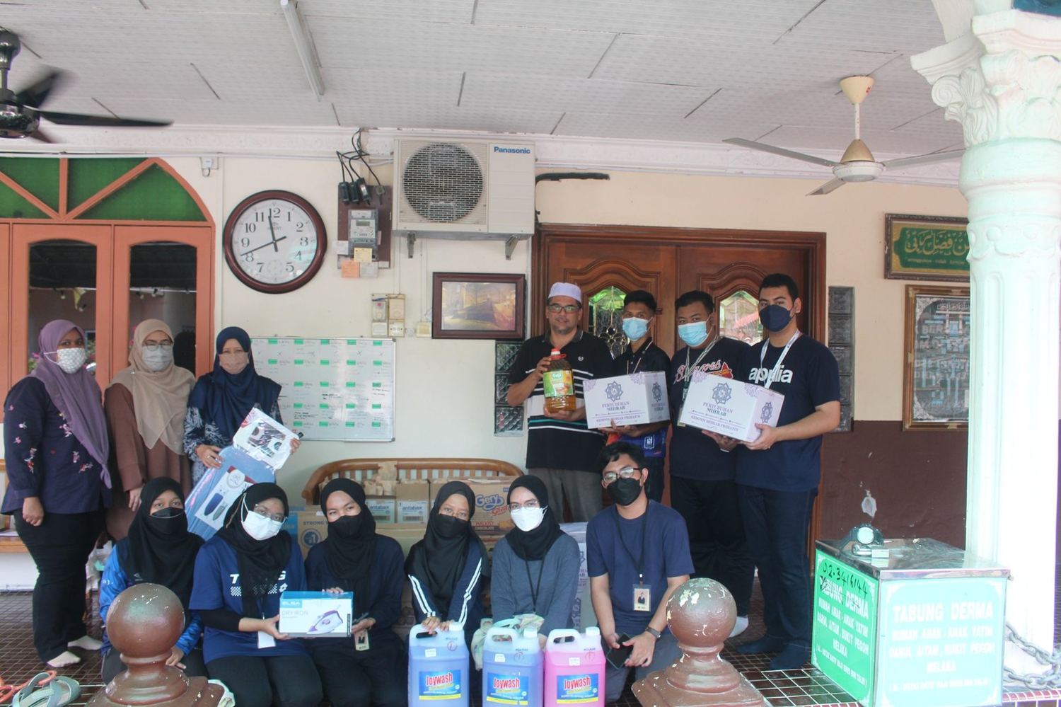 Sukarelawan bersama penerima bantuan dan barangan asas Kempen Satu Hati