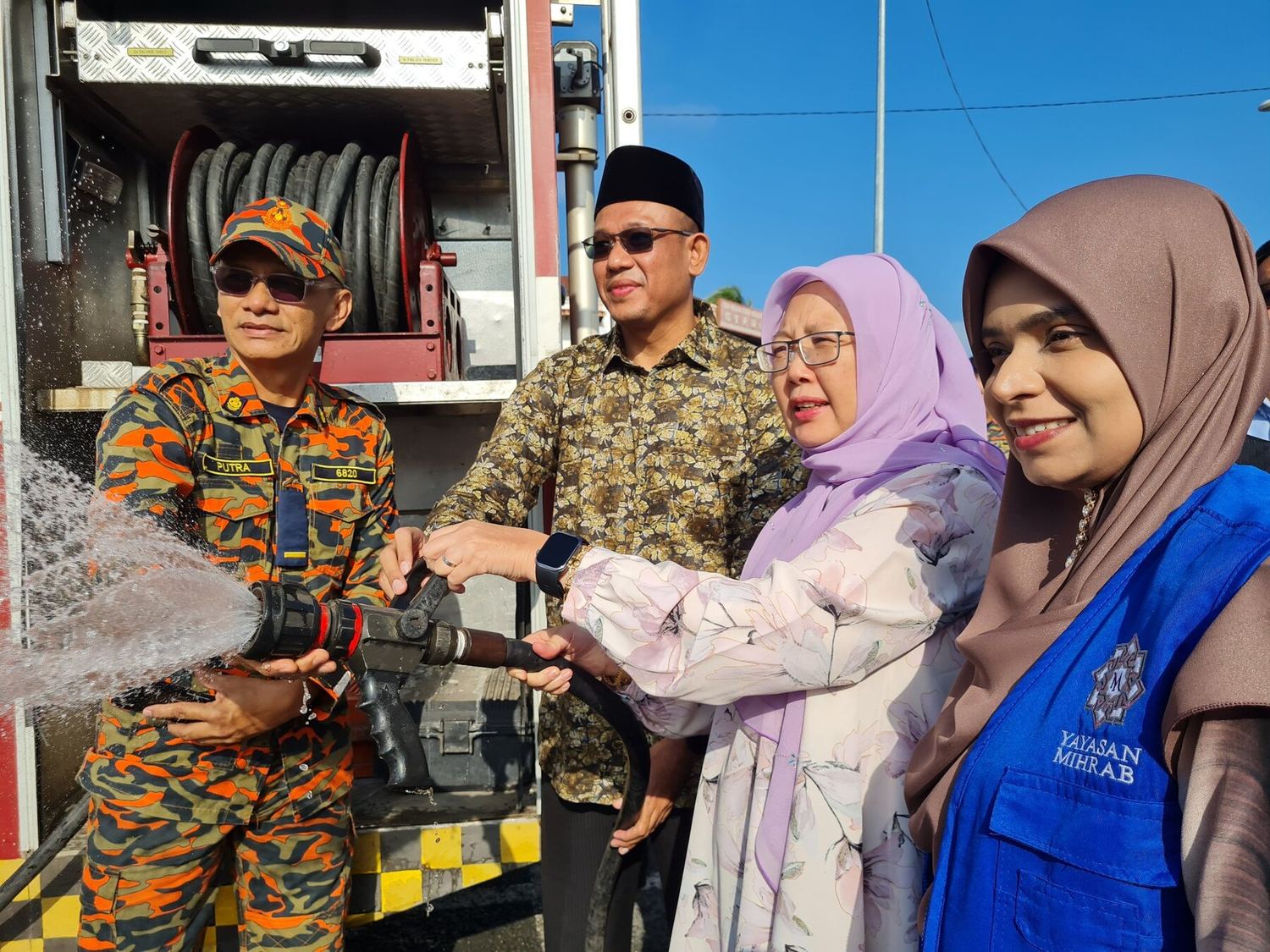 Wakil Yayasan Mihrab bersama pasukan bomba dalam aktiviti kolaborasi komuniti.